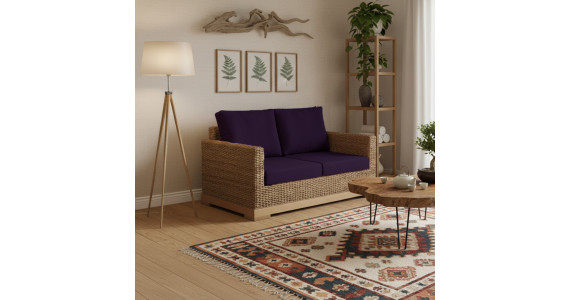 Petit canapé biologique et naturel à l’emplacement salon, avec coussins violets, table basse en bois et étagère végétale.