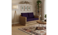 Petit canapé biologique et naturel à l’emplacement salon, avec coussins violets, table basse en bois et étagère végétale.
