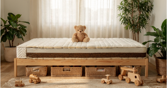 Matelas bio pour enfants et ados: grand lit en bois avec matelas moelleux et ours en peluche, entouré de plantes d’intérieur et